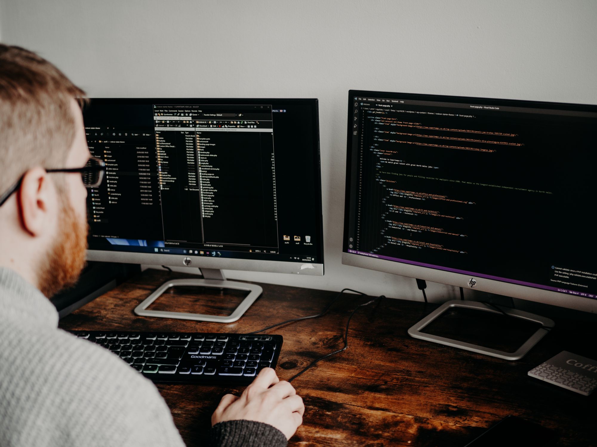 Developer working at two monitors with code visible
